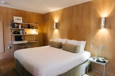 a bedroom with a large white bed and a book shelf at Seahorse Studio, Aldeburgh in Aldeburgh