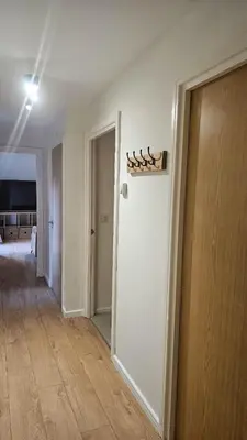 an empty room with a white wall and a hallway at The Retreat at Harlow in Potter Street