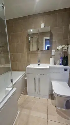 a bathroom with a sink and a toilet and a tub at The Retreat at Harlow in Potter Street