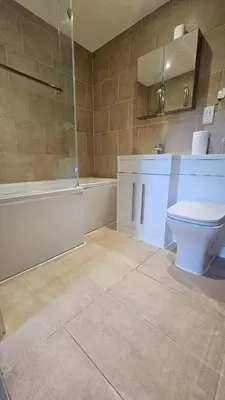 a bathroom with a toilet and a sink and a tub at The Retreat at Harlow in Potter Street