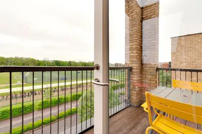 a balcony with a yellow bench and a view of a street at Pass the Keys Stunning and Spacious Modern Flat - Own Car Park in Cambridge