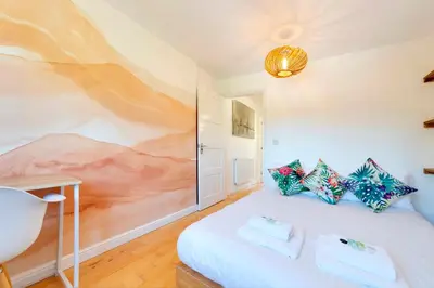 a bedroom with a bed with a painting on the wall at Pass the Keys Modern & Spacious 1 Bed Terrace with Free Parking in Cambridge