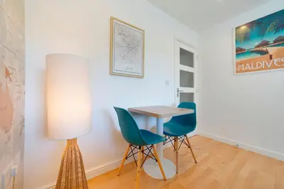 a table and chairs in a room with a lamp at Pass the Keys Modern & Spacious 1 Bed Terrace with Free Parking in Cambridge
