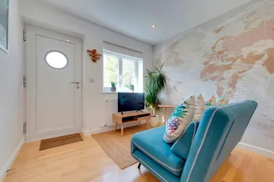 a living room with a blue couch and a window at Pass the Keys Modern & Spacious 1 Bed Terrace with Free Parking in Cambridge