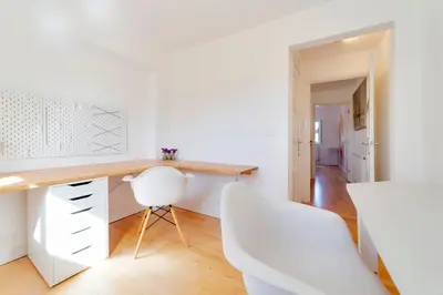 a white kitchen with a desk and two white chairs at Pass the Keys Modern & Spacious 1 Bed Terrace with Free Parking in Cambridge