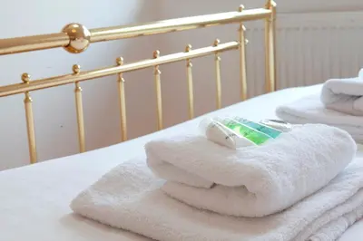 a pile of towels sitting on top of a bed at Pass the Keys 49 Byron Square Modern and Spacious 3 Bed Home with Free Parking in Cambridge