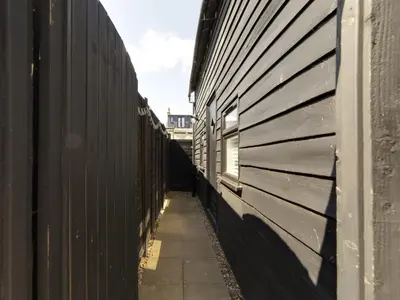 a hallway of a fence next to a building at Pass the Keys 19th Century Barn with Free Parking in Histon