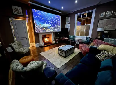 a living room with a large screen tv and a couch at Luxury Georgian House With Sauna Sleeps 19-23 in Harleston