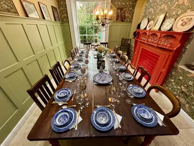 a long dining table with blue and white dishes on it at Luxury Georgian House With Sauna Sleeps 19-23 in Harleston