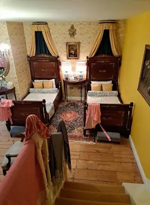 a bedroom with two beds and a table and a staircase at Luxury Georgian House With Sauna Sleeps 19-23 in Harleston