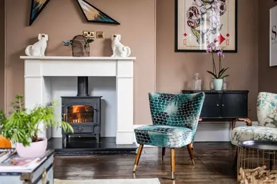 a living room with a fireplace and a chair at Luxury Georgian House With Sauna Sleeps 19-23 in Harleston