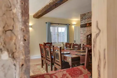 a dining room with a table and chairs and a fireplace at Josua Medieval Living Maldon in Maldon
