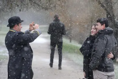a man taking a picture of people in the snow at Gonville Hotel in Cambridge