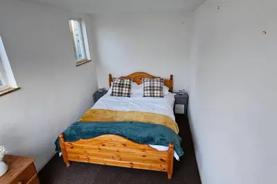 a bedroom with a wooden bed with two pillows at Beautiful Spacious 5 Bed House in Fornham Saint Martin
