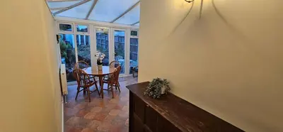 a conservatory with a table and chairs and a dining room at Beautiful Spacious 5 Bed House in Fornham Saint Martin