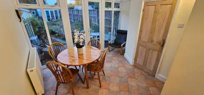 a dining room with a table and chairs and a door at Beautiful Spacious 5 Bed House in Fornham Saint Martin