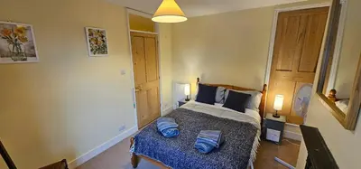 a bedroom with a bed with blue pillows on it at Beautiful Spacious 5 Bed House in Fornham Saint Martin