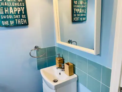 a bathroom with a white sink and a mirror at 3 Bedroom House Garden Free Parking 15 min to centre 5 min to motorway in Cambridge