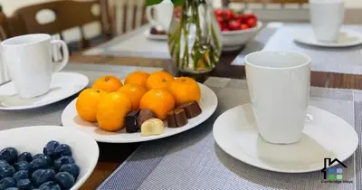 a table with plates of fruit and cups on it at 3 Bedroom House Garden Free Parking 15 min to centre 5 min to motorway in Cambridge