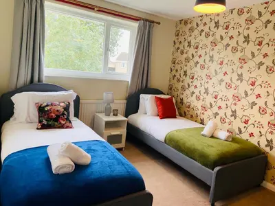 a bedroom with two beds and a window at 3 Bedroom House Garden Free Parking 15 min to centre 5 min to motorway in Cambridge