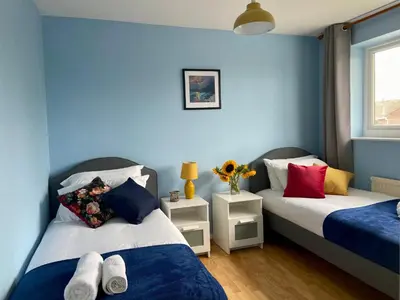 two beds in a room with blue walls at 3 Bedroom House Garden Free Parking 15 min to centre 5 min to motorway in Cambridge