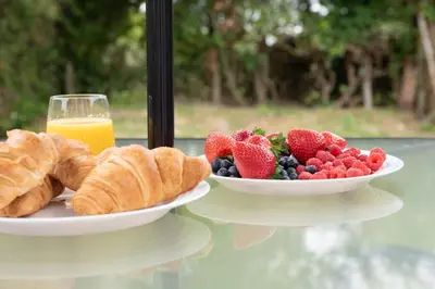 two plates of fruit and croissants and a glass of orange juice at 3 Bedroom House Garden Free Parking 15 min to centre 5 min to motorway in Cambridge