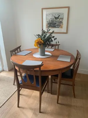 a wooden table with chairs and a vase with flowers on it at Beautiful Apartment Wendens Ambo in Wendens Ambo