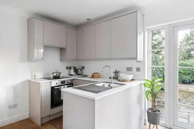 a white kitchen with white cabinets and a sink at Beautiful Apartment Wendens Ambo in Wendens Ambo