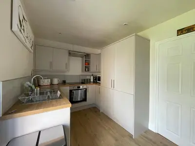 a kitchen with white cabinets and a white door at Hidden gem in heart of Breckland in Watton