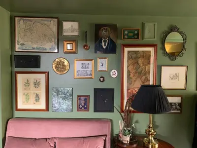 a living room with a pink couch and a wall of pictures at Hidden gem in heart of Breckland in Watton