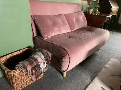 a brown couch sitting in a room with a basket at Hidden gem in heart of Breckland in Watton