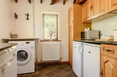 a kitchen with a washing machine and a microwave at 1 Bed in Saxmundham oc-c27420 in Farnham
