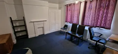a waiting room with chairs and pink curtains at Marina House in Ipswich