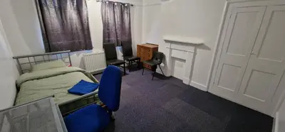 a bedroom with a bed and a desk and a door at Marina House in Ipswich