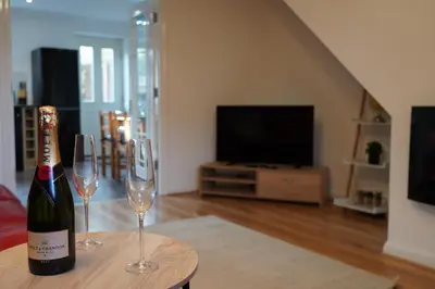 a bottle of champagne and two wine glasses on a table at Duxford Deluxe in Thriplow