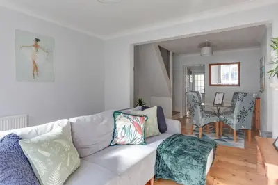 a living room with a couch and a dining room at Roman Cottage Chelmsford in Chelmsford