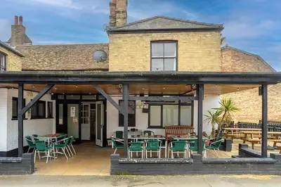 a house with a patio with tables and chairs at The George Hotel in Chatteris