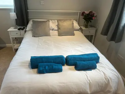 a white bed with two blue pillows on it at 29a in Downham Market