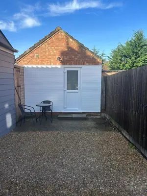 a white shed with a table and two chairs at 29a in Downham Market