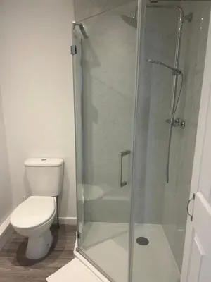 a bathroom with a toilet and a glass shower at 29a in Downham Market