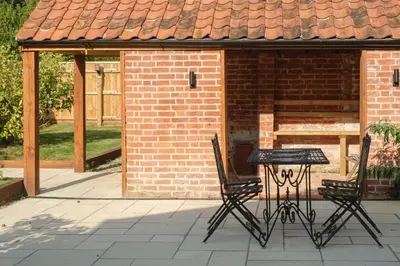 a table and two chairs in front of a brick building at Hole in One in Aldeburgh