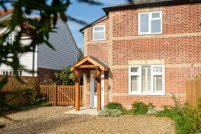 a brick house with a wooden door in front of it at Hole in One in Aldeburgh