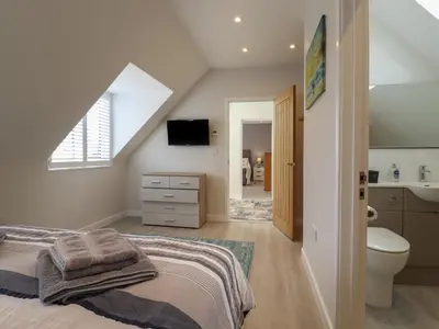 a attic bedroom with a bed and a bathroom at Wellington Cottage in Ely