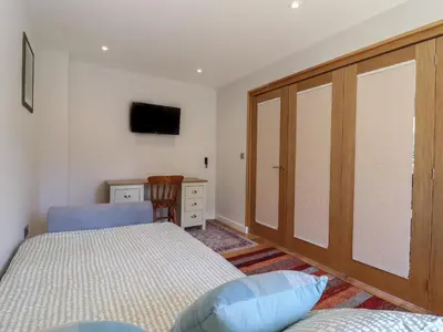 a bedroom with a bed and a sliding glass door at Wellington Cottage in Ely