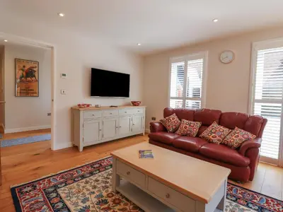 a living room with a couch and a flat screen tv at Wellington Cottage in Ely