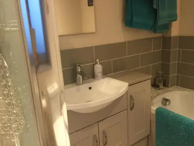 a bathroom with a sink and a toilet and a tub at STACK YARD COTTAGE. in Cambridge