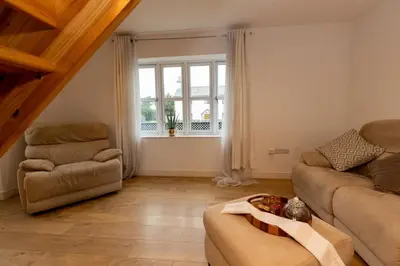 a living room with a couch and a chair at The Poppies Cottage in Six Mile Bottom