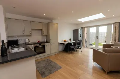 a kitchen and living room with a couch and a table at The Poppies Cottage in Six Mile Bottom