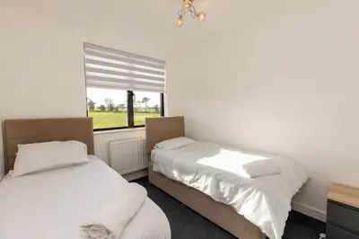 two beds in a room with a window at The Mayfair in Six Mile Bottom