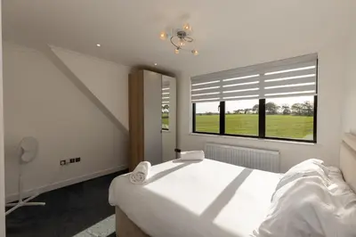 a bedroom with a large white bed and a window at The Mayfair in Six Mile Bottom